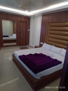 a bedroom with a large bed and a mirror at HOTEL NL7 in Dimāpur