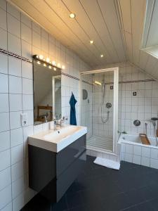 a bathroom with a sink and a shower and a tub at Zum schönen Ausblick in Weißenthurm