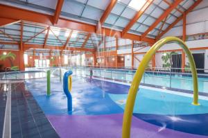 uma grande piscina interior com água amarela e azul em Lovely 2-Bed Lodge in St Osyth em Clacton-on-Sea