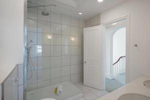 biała łazienka z prysznicem i umywalką w obiekcie Beautiful maisonette in the heart of Chelsea w Londynie
