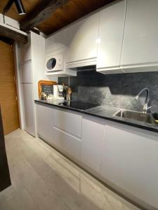 a kitchen with white cabinets and a sink at Las Casas de Quintanilla 3 in Quintanilla las Torres