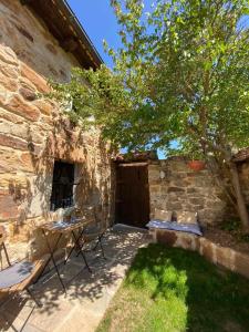 un patio con mesa, sillas y un árbol en Las Casas de Quintanilla 3, en Quintanilla las Torres