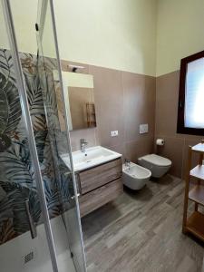 een badkamer met een wastafel, een toilet en een spiegel bij Villa Blue Paradise - B&B con piscina non lontano da Cagliari in Cagliari