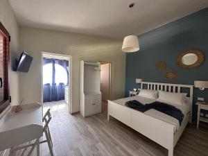 een slaapkamer met een bed, een bureau en een spiegel bij Villa Blue Paradise - B&B con piscina non lontano da Cagliari in Cagliari