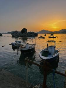 a group of boats in the water at sunset at Varja 2 Apartment in Sveti Stefan