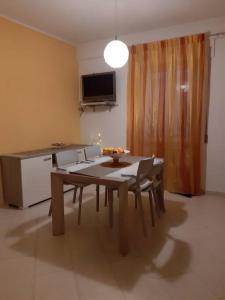 ein Esszimmer mit einem Tisch, Stühlen und einem TV in der Unterkunft The family nest comodo appartamento nei pressi della stazione centrale in Sulmona