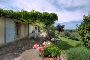 um pátio de uma casa com uma mesa e flores em allegretti agriturismo em Castelnuovo Berardenga