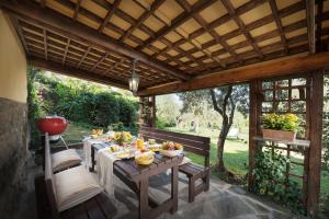 eine Terrasse mit einem Tisch mit Essen darauf in der Unterkunft Casa del Sole 4, Emma Villas in Cortona