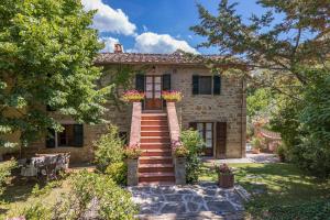 ein Steinhaus mit Treppen und Blumen im Hof in der Unterkunft Casa del Sole 4, Emma Villas in Cortona