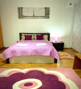 a bedroom with a large bed with a pink blanket at Andreea Residence in Ghimbav