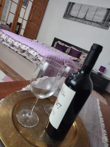 a bottle of wine and a glass on a table at Andreea Residence in Ghimbav