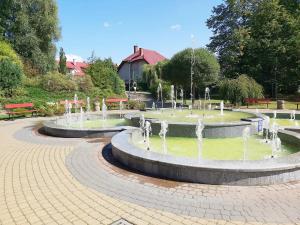 two water fountains in a park with benches at Apartament Parkowa 2 in Morąg