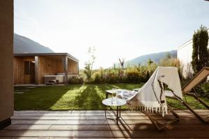 eine Terrasse mit 2 Stühlen und einem Tisch im Hof in der Unterkunft Amolaris in Goldrain