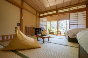 Schlafzimmer mit einem Bett, einem Tisch und einem Fenster in der Unterkunft Kamei no Yu in Yamanouchi