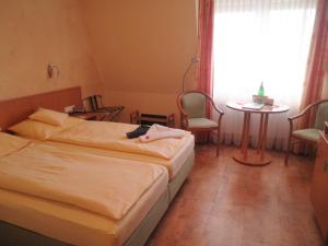 a hotel room with two beds and a table and a window at Hotel "Pension" Strandkorb in Norddeich