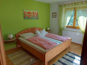 ein Schlafzimmer mit einem Holzbett in einem grünen Zimmer in der Unterkunft Apartment in Münster/Tirol 450 in Grünsbach