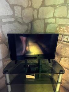 a flat screen tv sitting on a glass table at Gloria Holiday Homes Apartments in Lithakia