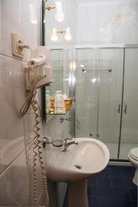 a bathroom with a sink and a shower and a phone at Hotel Oasis in Santa Marta de Penaguião