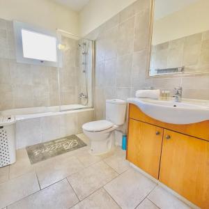 a bathroom with a toilet and a sink and a shower at Mediterranean Breeze Villa in Protaras