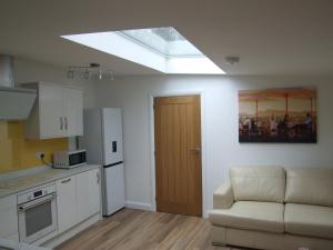 a kitchen with a skylight and a couch in a room at Charming 1-Bed Lodge in woodland setting in Great Yarmouth