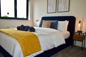 una camera da letto con un grande letto con una coperta gialla di Bright Stylish Apt in Bedford a Bedford