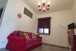 ein Wohnzimmer mit einem lila Sofa und einem Kronleuchter in der Unterkunft Villa in campagna vicina al mare Bonerelax in Menfi