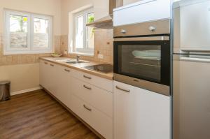 a kitchen with white cabinets and a stainless steel appliance at Villa Sv. Martin in Mali Lošinj