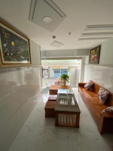 胡志明市的住宿－Khách sạn Thanh Bình 3，客厅配有桌子,墙上挂有绘画作品
