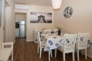 a dining room with a table and chairs and a clock at Villa Sv. Martin in Mali Lošinj