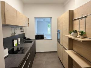 una cocina con encimeras negras y armarios de madera en Apartment Wesseling, en Wesseling