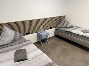 ein Schlafzimmer mit 2 Betten und einem Beistelltisch mit einer Lampe in der Unterkunft Apartment Wesseling in Wesseling