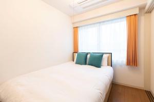 a bedroom with a white bed and a window at COSMOS REID Minamiazabu in Tokyo