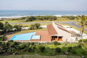 een luchtzicht op een huis met een zwembad en de oceaan bij Laguna La Crete 6 in Uvongo Beach
