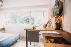 1 dormitorio con escritorio, chimenea y cama en Le Viotte - Unique ! 3 logements disponibles, en Besançon