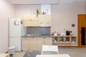 a kitchen with wooden cabinets and a white refrigerator at Sicily Loft Catania few min from sea - Happy Rentals in Catania