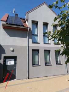 una casa con paneles solares en el techo en Apartament Parkowa 2, en Morąg