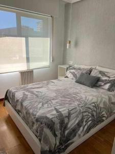 un dormitorio con una cama con un patrón de planta en Mi Refugio, en Vigo