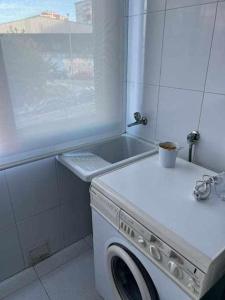 baño con ventana y lavadora blanca en Mi Refugio, en Vigo