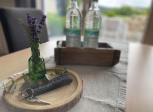a wooden tray with a vase of flowers and a bottle at Appartement Burgblick in Harburg