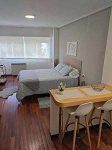 a bedroom with a bed and a table and chairs at La Cabaña in Vigo