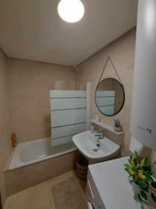 a bathroom with a tub and a sink and a mirror at La Cabaña in Vigo