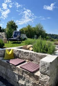 a stone retaining wall with a bench in a yard at Appartement Burgblick in Harburg