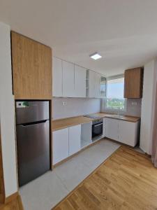 a kitchen with white cabinets and a stainless steel refrigerator at PETKOV5KI.LuxuryApartments in Skopje