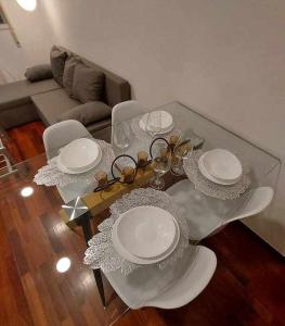 - une table en verre avec des plaques dans le salon dans l'établissement Apartamentos Florida Casablanca, à Vigo