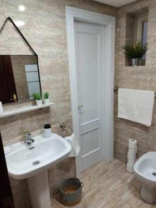 a bathroom with a sink and a toilet and a mirror at Apartamentos Florida Casablanca in Vigo