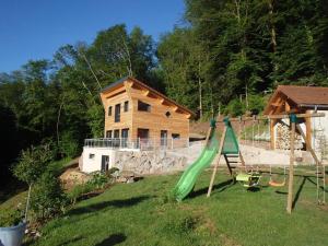 a playground with a house and a green slide at Villa Cora Venez avec spa in Saint-Bresson