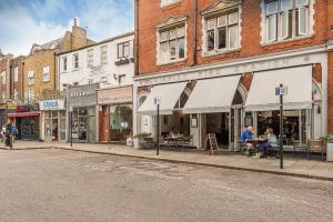 a street with shops and buildings on a city street at Hidden Gem in Chiswick, Stylish 1 Bedroom House in London
