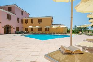 un libro abierto sentado en una mesa junto a una piscina en ISA - Residence with swimming pool in Sos Alinos, apartments with air conditioning and private outdoor area, en Cala Liberotto
