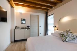 a bedroom with a white bed and a bathroom at Charming Sirmione in Sirmione