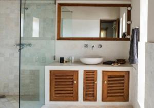 a bathroom with a sink and a glass shower at SaffronStays Stella Maris - Luxury Beach Front Villa Near Redi Beach in Querim